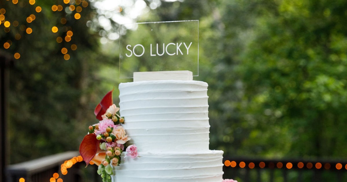 Wedding cake with topper that says: So Lucky